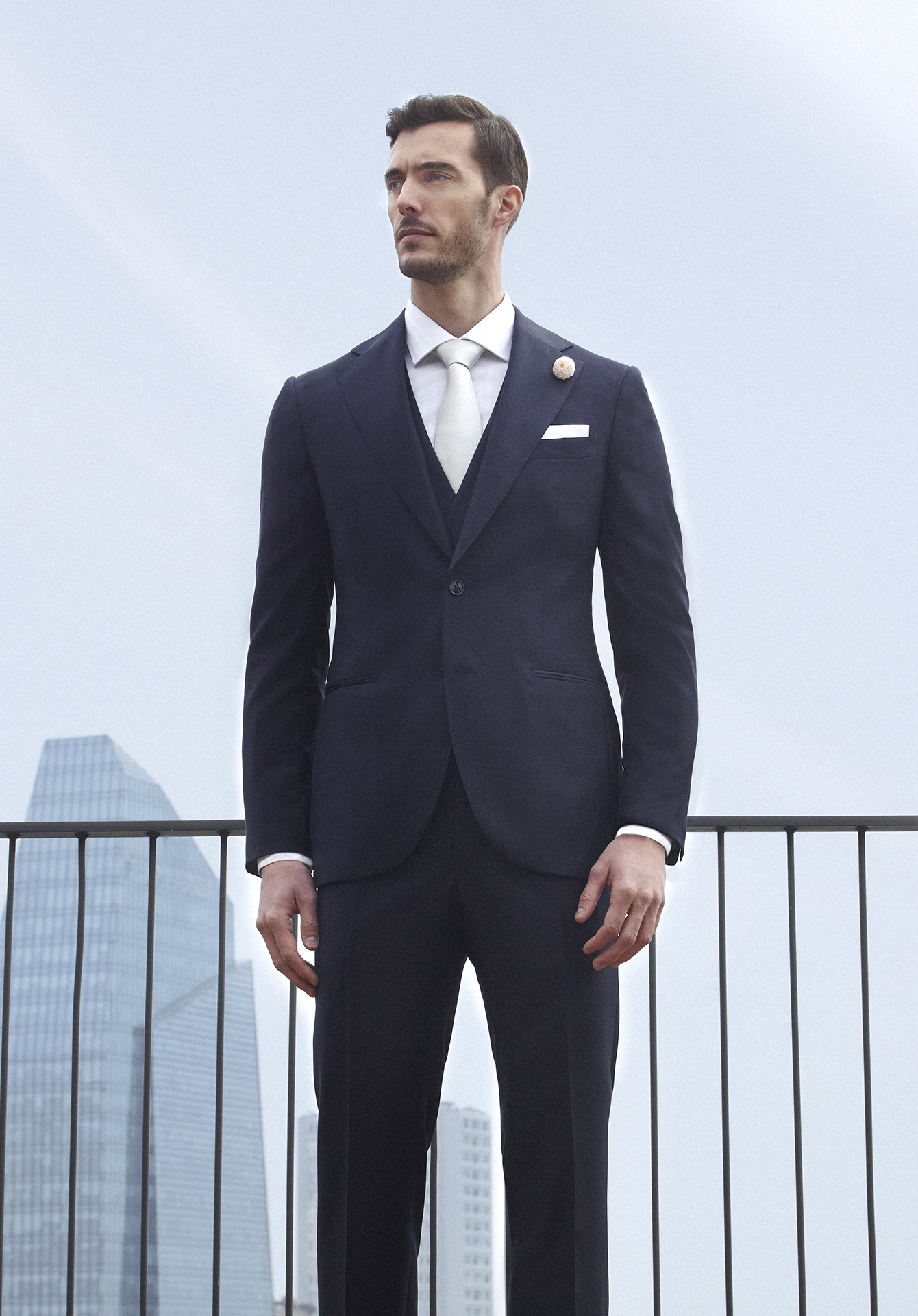 Midnight blue double-breasted ceremony suit with white pocket square and buttonhole
